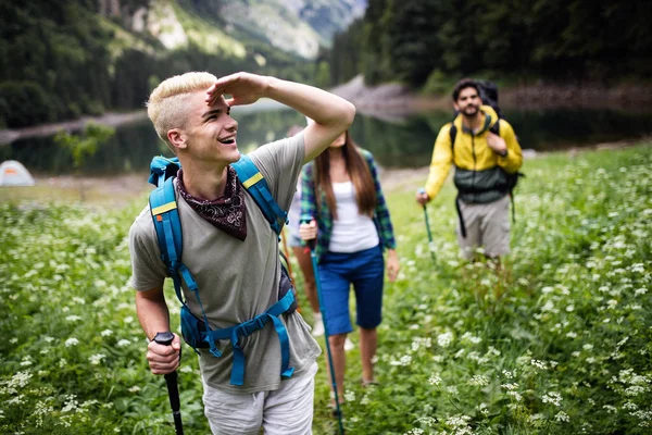 Group of friends with backpacks trekking together in nature