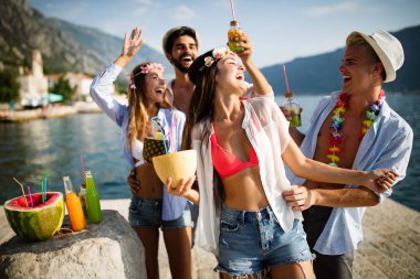 Genç ve eğlenceli insanlar sahilde yazın tadını çıkarıyor.