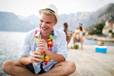 Genç ve eğlenceli insanlar sahilde yazın tadını çıkarıyor.