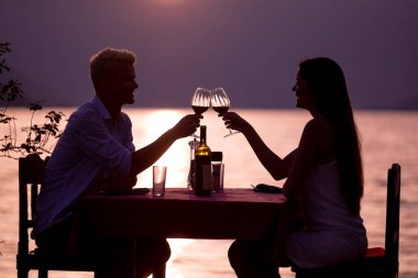Mutlu genç çift yaz akşamında romantik bir akşam yemeği yiyor.
