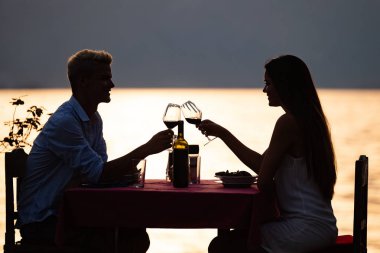 Tropikal tatil akşam yemeği sırasında tost genç romantik çift