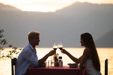 Mutlu genç çift yaz akşamında romantik bir akşam yemeği yiyor.
