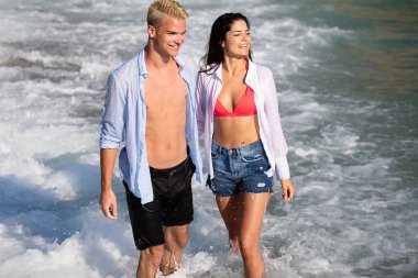 Genç çift sahilde eğleniyor.