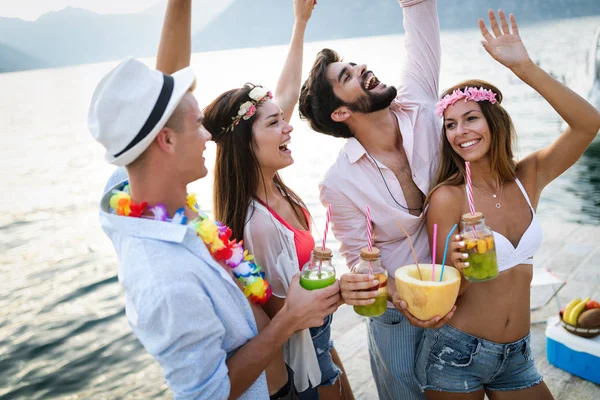 ビーチで一緒に楽しみ カクテルを飲む友人のグループ — ストック写真