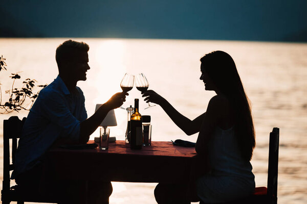 Young romantic couple toasting during dinner on tropical resort