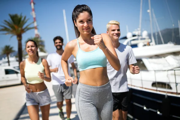 Happy people jogging outdoor. Running, sport, friends, exercising and healthy lifestyle concept