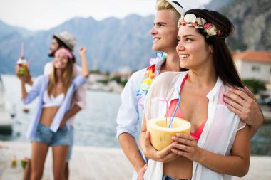 Bir grup arkadaş sahilde dans edip eğleniyorlar. Plajda yaz tatili partisi