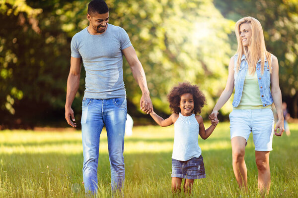 Счастливая молодая пара проводит время со своей дочерью на природе
