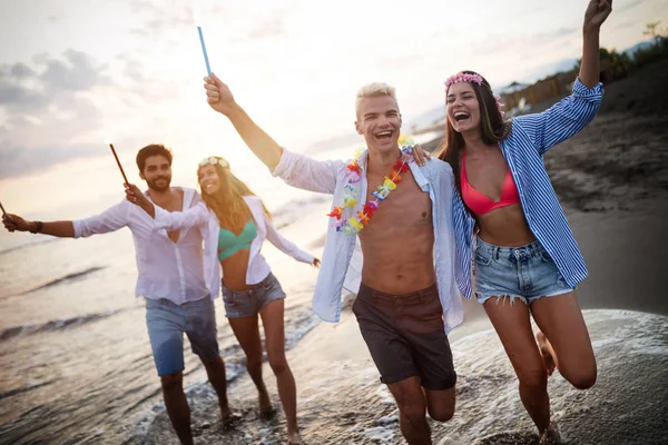 Grupo Amigos Felices Divirtiéndose Corriendo Por Playa Con Bengalas — Foto de Stock