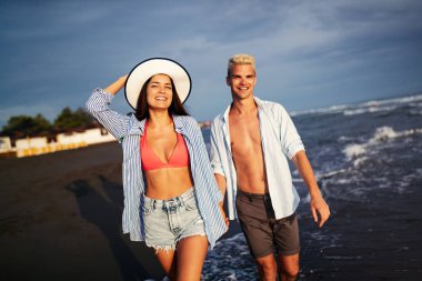 Sahilde birbirine aşık gülümseyen bir çift.