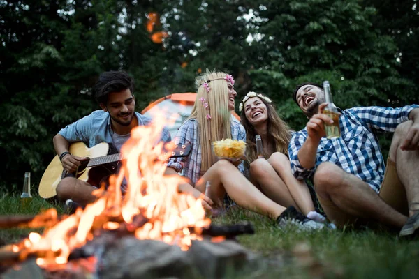 音楽を演奏し 自然の中でたき火を楽しむ幸せな友人 — ストック写真