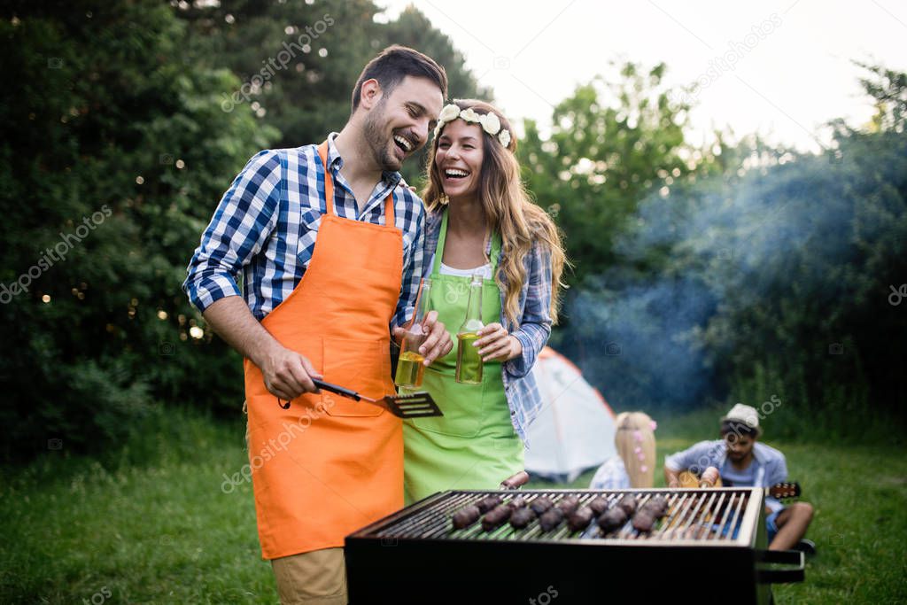 Friends having a barbecue party in nature while having fun