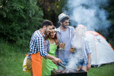 Arkadaşlar doğada bbq yaparak eğleniyorlar.