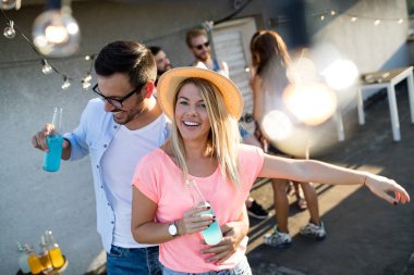 Bir çatı partisinde eğlenen, gitar çalan, şarkı söyleyen, dans eden ve sakinolan genç arkadaşlar