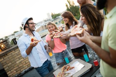 Arkadaşlar ve pizza. Bir grup genç neşeli insan pizza yiyip eğleniyor