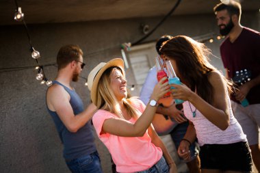 Çatıda parti ve eğlence olan mutlu arkadaşlar grubu