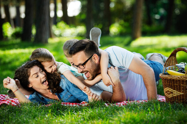 Happy male and female playing with children outside