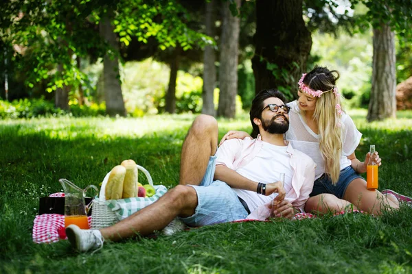 快乐的年轻夫妇享受野餐在公园户外 — 图库照片