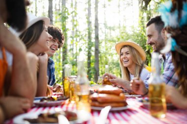 Barbekü yapma ve doğada yemeğe mutlu arkadaşlar