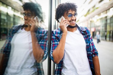 Genç Afrikalı adam gülümseyen ve cep telefonu dışında konuşuyor