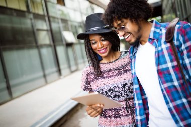 Çekici genç Afrikalı Öğrenciler dijital tablet kullanıyor ve açık ayakta iken gülümseyen