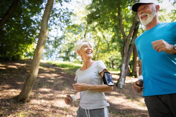 Healthy mature couple jogging in a park at early morning