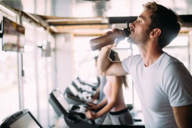 Yakışıklı sportif fit adam dinlenme, egzersiz yaptıktan sonra içme suyu kırmak sahip