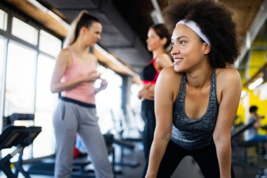 Modern spor salonunda eğitim gören bir grup insan.