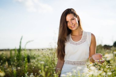 Genç, güzel, mutlu bir kadın doğada vakit geçiriyor.