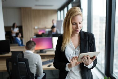 Modern ofiste dijital tablet kullanan çekici bir iş kadını