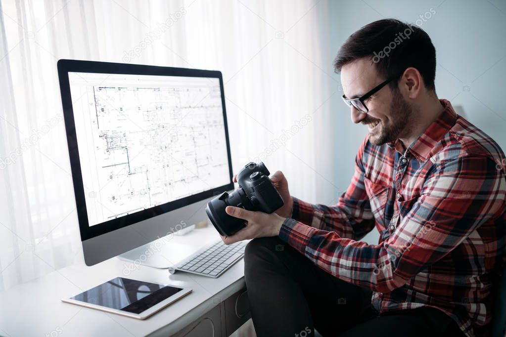 Young attractive designer working on project at home