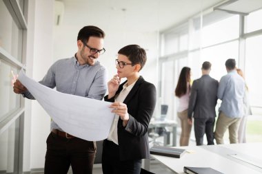 Bir grup mimar ve iş adamı birlikte çalışıyor ve beyin fırtınası yapıyorlar.