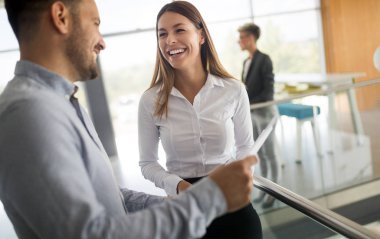 Modern ofis lobisinde iş adamları belgeler üzerinde tartışıyor..