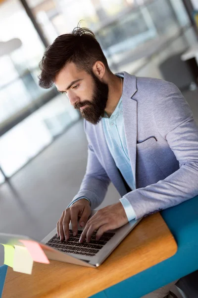 Portret van de jonge man zittend op Bureau in het kantoor — Stockfoto