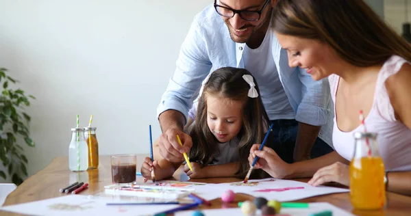 Pappa en mamma tekenen met hun dochter — Stockfoto