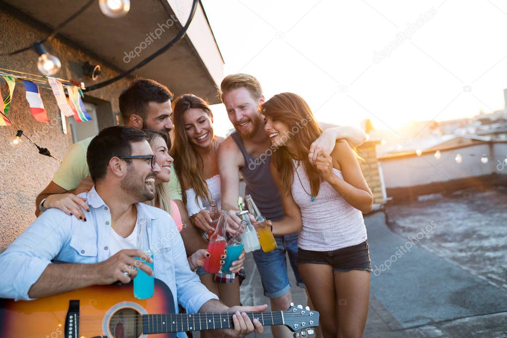 Group of happy friends having party and fun on rooftop