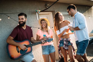 Çatıda parti ve eğlence olan mutlu arkadaşlar grubu