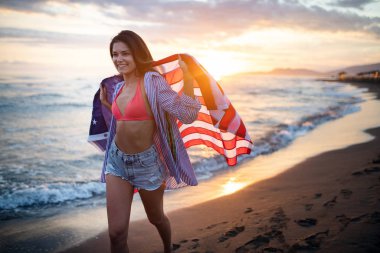 Mutlu kadın gülümseyip plajda koşarken bağımsızlık gününü kutluyor ve Amerika 'da özgürlüğün tadını çıkarıyor.