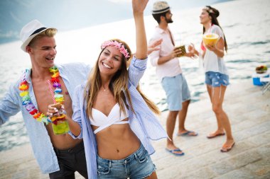 Bir grup arkadaş sahilde dans edip eğleniyorlar. Plajda yaz tatili partisi