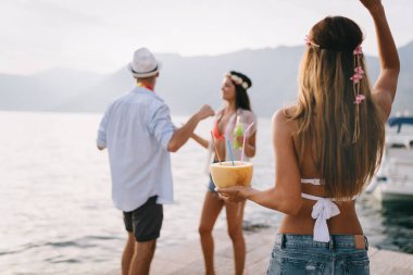 Bir grup arkadaş sahilde dans edip eğleniyorlar. Plajda yaz tatili partisi