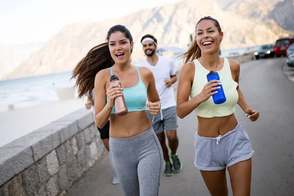 Healthy fit people running and jogging together in summer sunny nature