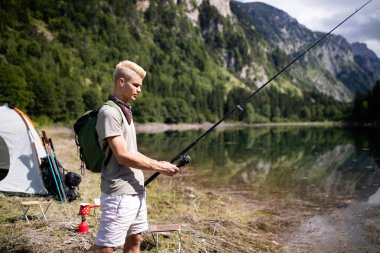 Açık alanda kamp yaparken gölde doğada balıkçı balıkçılık