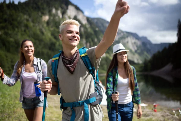 Group of friends with backpacks trekking together in nature