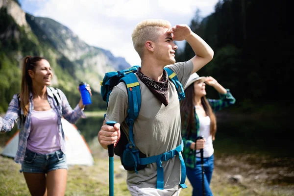 Group of friends with backpacks trekking together in nature