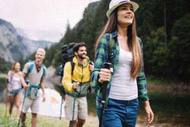 Gün batımında bir dağa yürüyen yürüyüşçüler ve arkadaşlar grubu