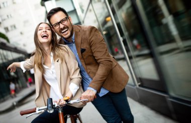 Genç çift şehirde eğleniyor. Bisiklete binen mutlu genç çift