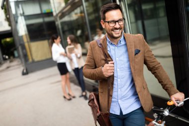 İş adamı sabah işe bisikletle gidiyor. Ofise giden yol.