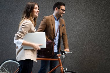 Mutlu iş adamları dışarıda yürürken tartışıyor ve gülümsüyor.