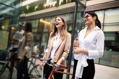 Genç güzel mutlu iş kadınları açık havada konuşuyor. Arka planda ofis binası.