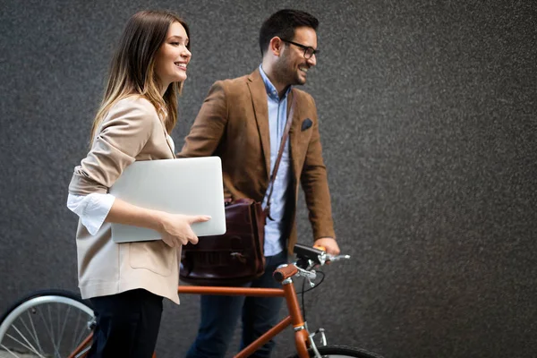 Mutlu iş adamları dışarıda yürürken tartışıyor ve gülümsüyor.